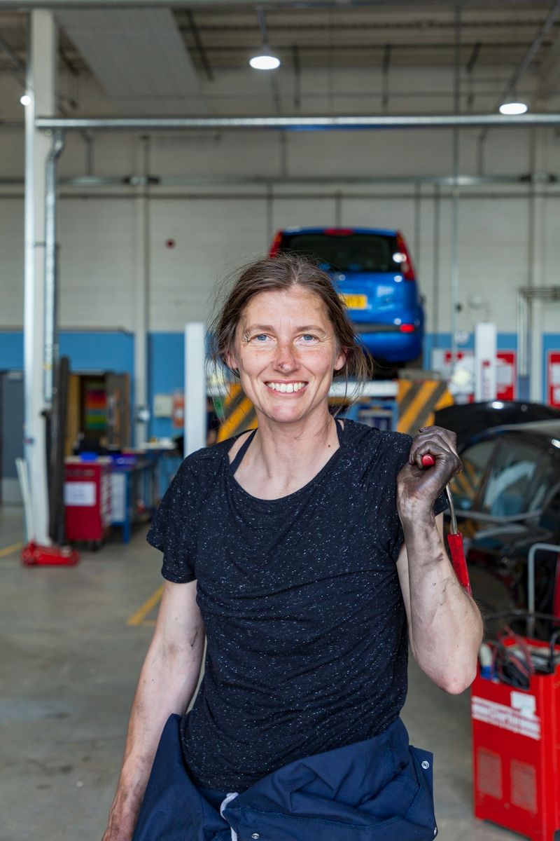 A smiling mechanic in an auto repair shop