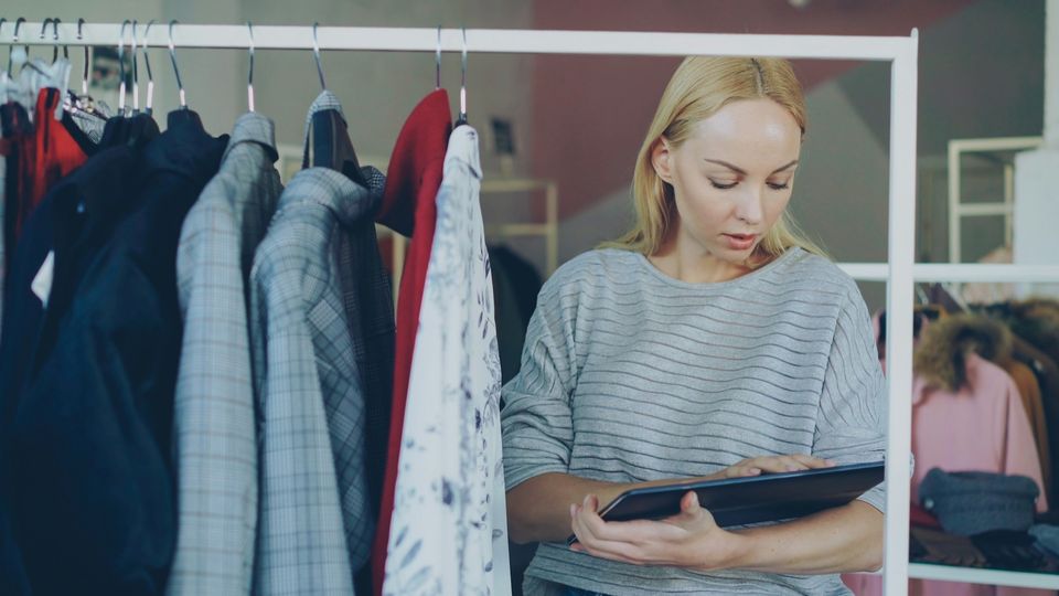 A boutique owner checking stock on a tablet